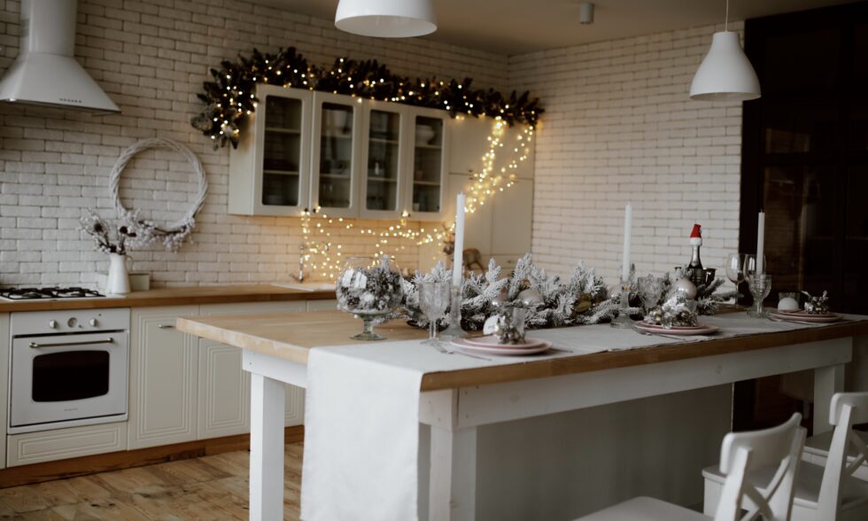 Organización de la cocina en Navidad con isla central despejada, accesorios colgados y decoración festiva sutil